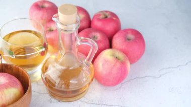 Cam şişede elma sirkesi ve masada taze yeşil elma. 