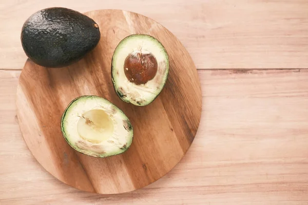 Bovenaanzicht van plak avocado op houten tafel — Stockfoto