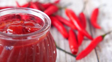 Kırmızı biber ve domates sosu masada küçük bir kavanozda. 