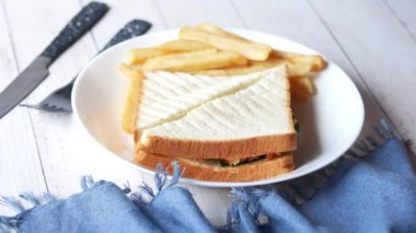  Tabakta tavuklu sandviç ve cips var. 