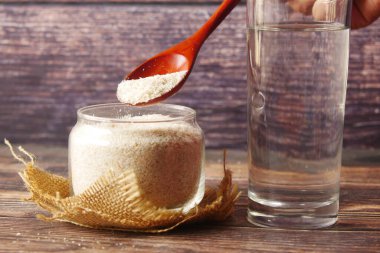 Psyllium tohumlar koyu arka plan üzerinde tahta kaşıkla