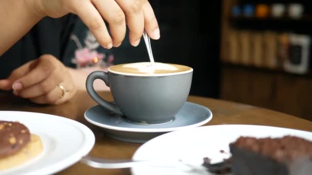 Osoba ruka míchání kávy s lžící. — Stock video