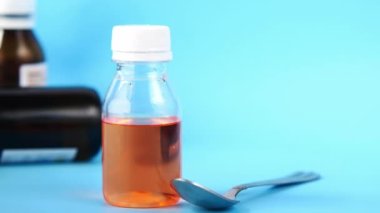 Mavi arka planda sıvı ilaç şişesi 