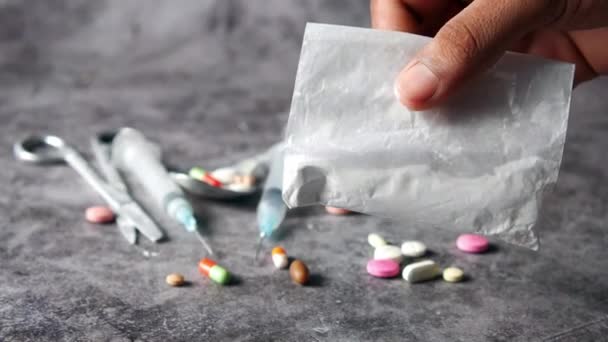 Conceito de dependência de drogas com mão segurando pacote de heroína no fundo preto — Vídeo de Stock