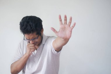  Genç hasta adam öksürüyor ve hapşırıyor. 