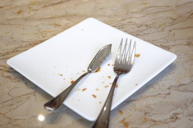 Çatal bıçak takımı ve tahta arka planda boş tabak 