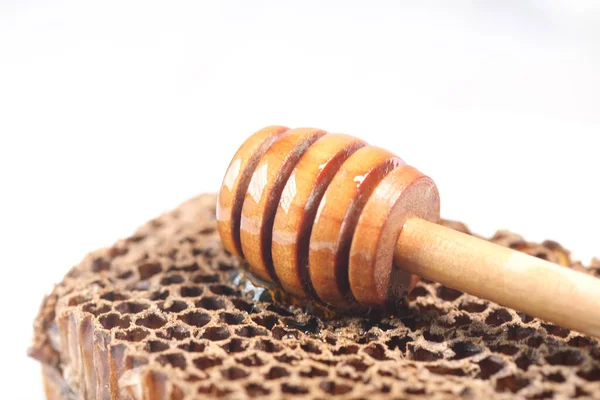 Čerstvý med s lžící a medovým hřebenem na bílém — Stock fotografie