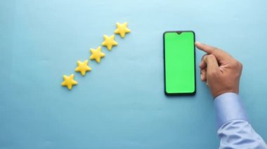 Müşteri değerlendirme konsepti. Altın yıldızları değerlendirmek ve akıllı telefon kullanmak 