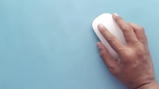 Hand with computer mouse on blue background — Stock Video
