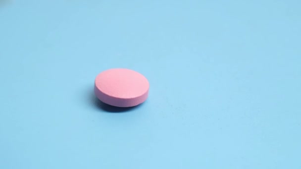 Pílulas médicas coloridas cai no fundo azul — Vídeo de Stock
