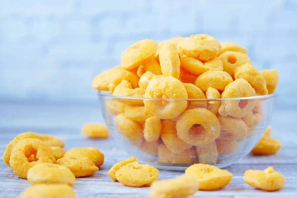 Puffed corn rings chips in black bowl on white background — Stock Photo, Image
