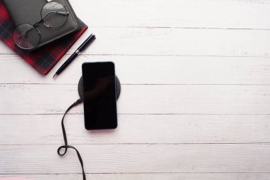 Kablosuz şarj pedi kullanarak akıllı telefon şarj ediliyor, üst görünüm 