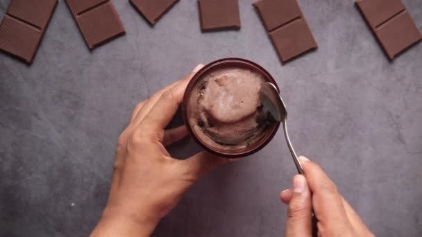 Vista superior del hombre comiendo helado sabor chocolate en un recipiente — Vídeo de stock