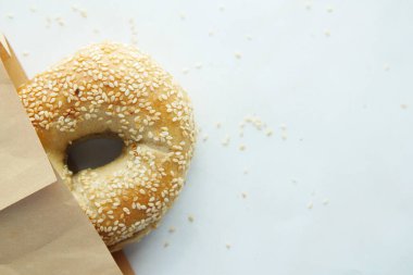Beyaz arkaplanda simit ve kağıt paketi 