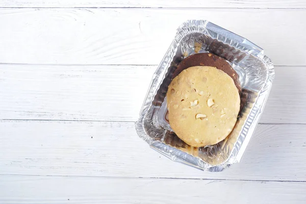 Gros plan de biscuits sucrés dans une boîte à emporter sur une table en bois — Photo