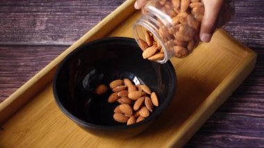  Masadaki bir kaseye badem fıstığı döküyorum. 