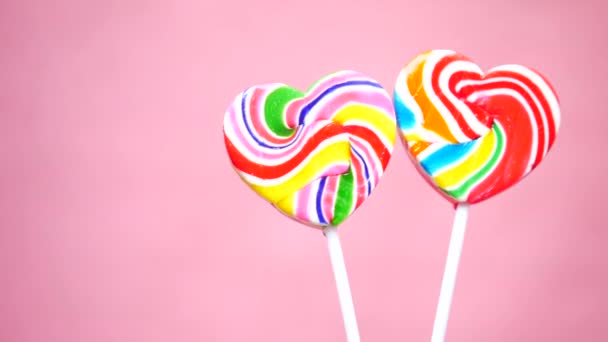 Rainbow heart shape candy on pink — Stock Video