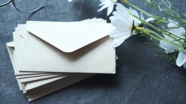 Stack of envelopes , flower and eyeglass on black background — Stock Video