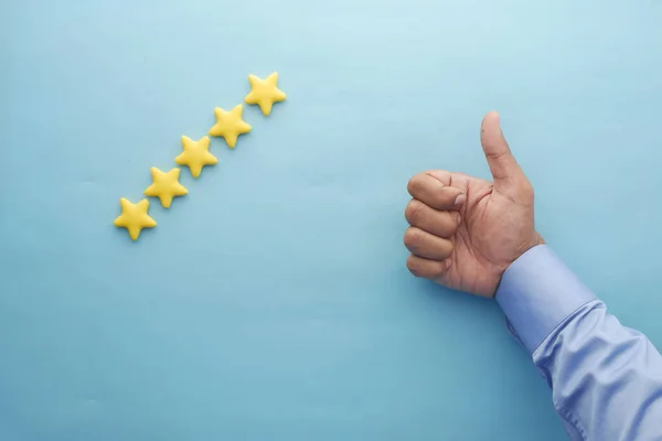 Kundenbewertungskonzept. Bewertung goldener Sterne auf blauem Hintergrund — Stockfoto