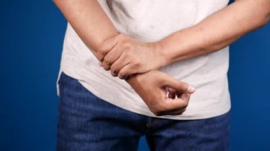 Mavi arka planda bilek desteği olan el.