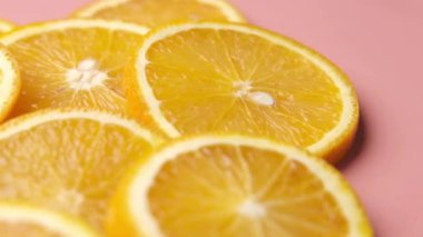 Pembe arka planda bir dilim portakal meyvesini kapat. 