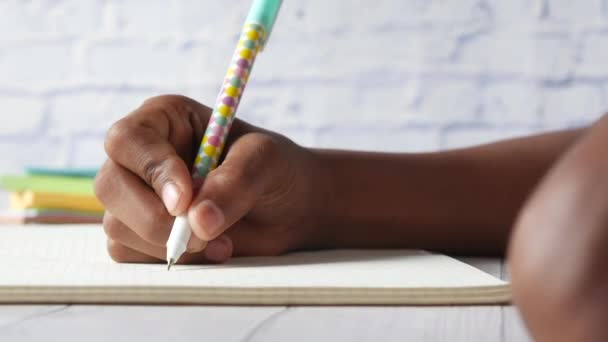 Child boy hand writing on notepad. — Stock Video