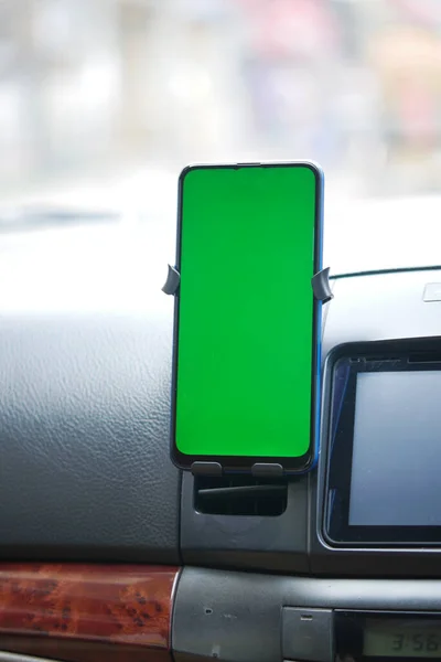Smartphone met groen scherm op het dashboard van de auto — Stockfoto