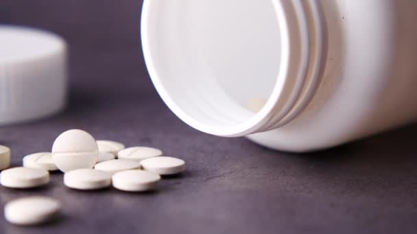 Pilules médicales de couleur blanche renversant sur le noir — Video