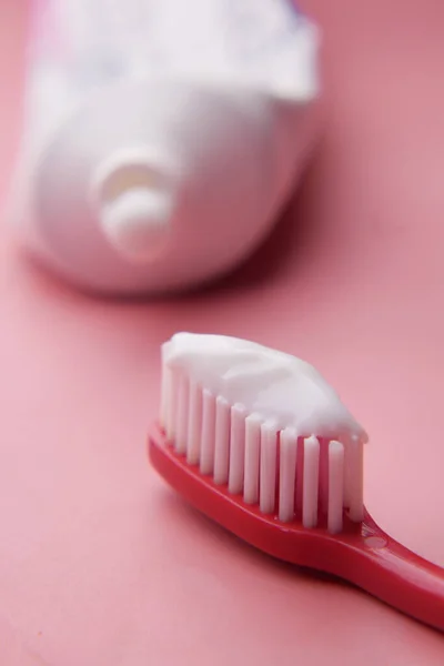 Zahnbürste und Paste auf rosa — Stockfoto