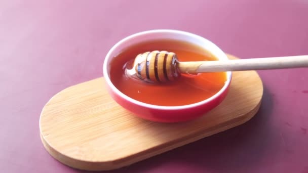 Primer plano de miel fresca con cuchara en la mesa — Vídeo de stock