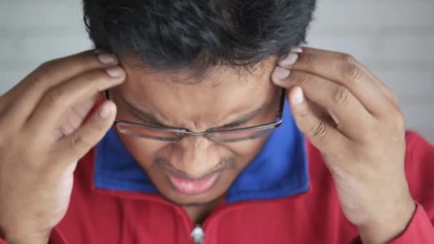 Młody człowiek cierpi na ból głowy, zbliżenie — Wideo stockowe