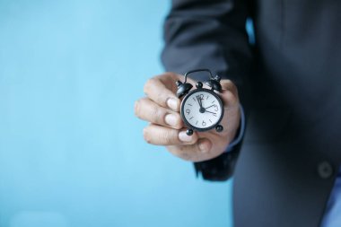 Mavi arkaplana karşı el ele alarmlı saat 