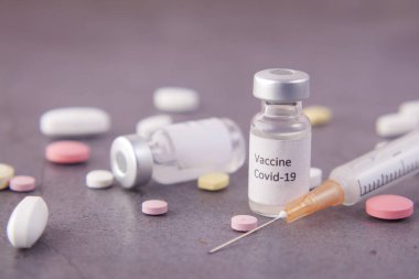 Koronavirüs aşısını ve siyah arka planda şırıngayı kapatın.