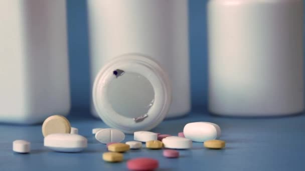 Pilules médicales multicolores renversant sur le bleu — Video