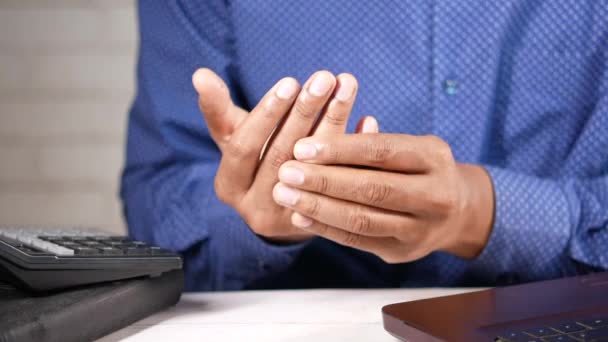 Jongeman in lijden pols pijn terwijl gezeten op kantoor — Stockvideo