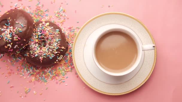 Schokoladen-Donuts und Kaffee auf rosa — Stockvideo