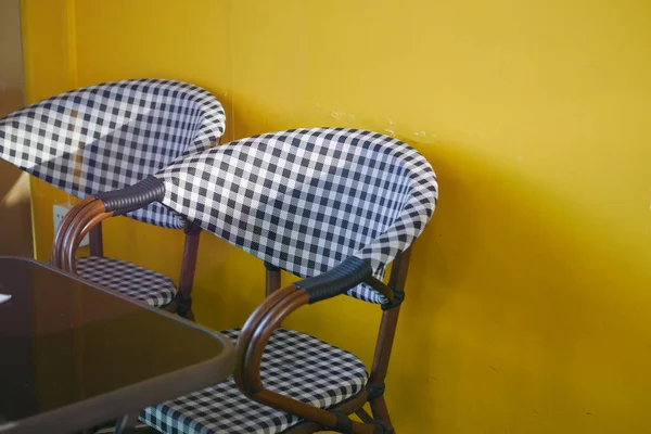 Cadeira vazia no café contra fundo amarelo — Fotografia de Stock