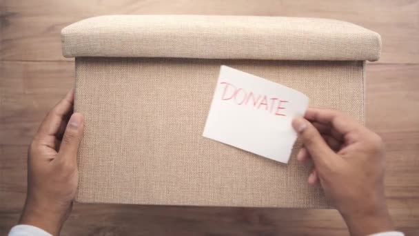Puncak tampilan tangan manusia memegang kotak sumbangan — Stok Video