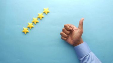 Müşteri değerlendirme konsepti. Mavi arkaplanda altın yıldızlar sıralanıyor 