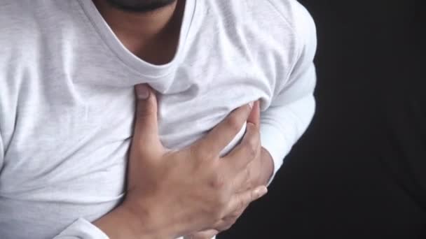 Young man suffering pain in heart and holding chest with hand — Stock Video