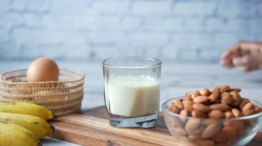  Çocuk elleriyle bir bardak süt seçiyor. 