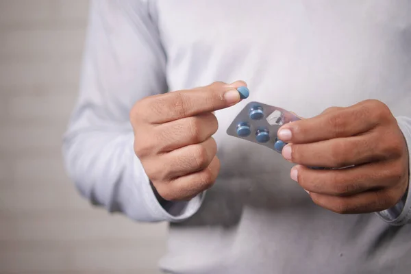 young man hand holding blister packs taking medicine