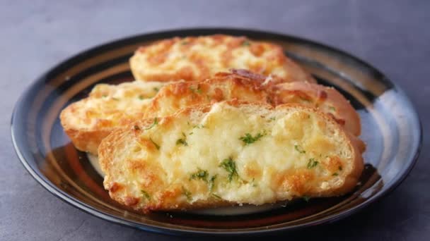 Recoger a mano un pan de ajo en un plato — Vídeo de stock