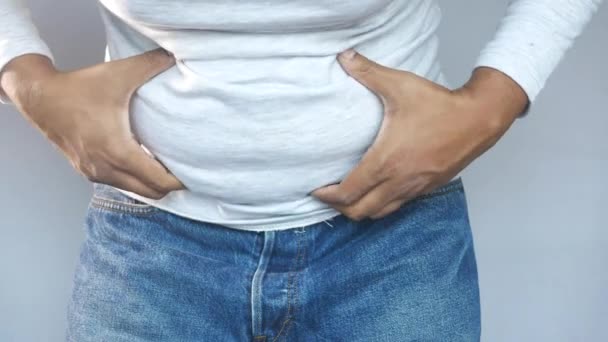 Mão mans segurando gordura excessiva da barriga, conceito de excesso de peso — Vídeo de Stock