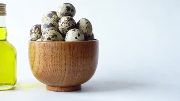 Vrchní pohled na křepelčí vejce v misce s olejem na bílém pozadí — Stock video