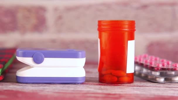 Pulse oximeter, medical pills and blister pack on table — Stock Video