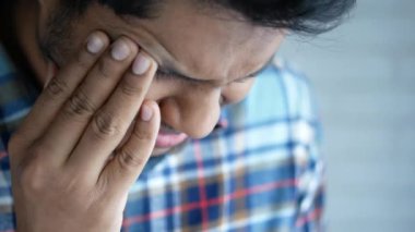 Güçlü göz ağrısından muzdarip üzgün adama yaklaş.