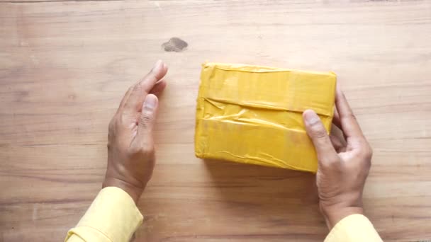 Mão segurar um pacote de entrega na mesa — Vídeo de Stock