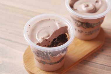 Masadaki konteynırda kremalı pasta. 