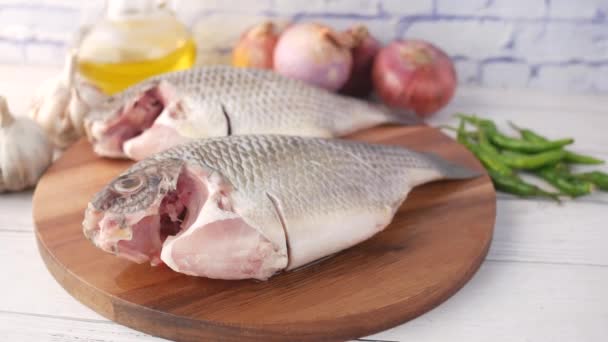 Pescado fresco crudo en una tabla de picar para prepararse para cocinar en la mesa , — Vídeo de stock